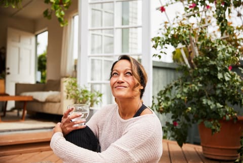 Smiling mature woman relaxing on her patio at home